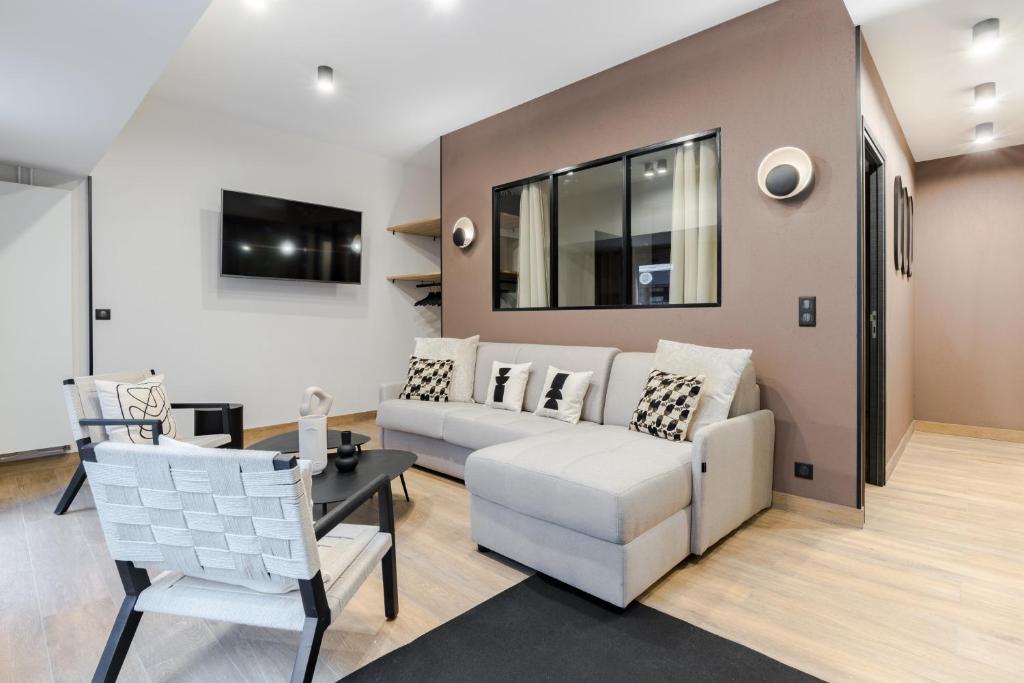uma sala de estar com um sofá e uma mesa em HSH Parmentier-Couronnes I Appartement Design 6P-2BR em Paris