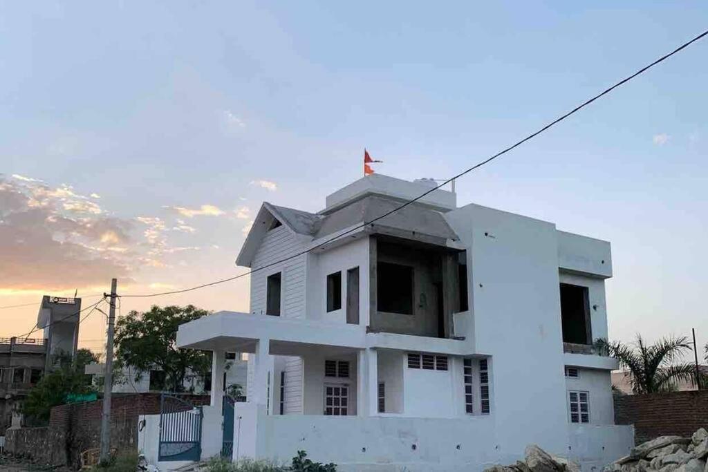 Una casa blanca con una cruz encima. en The White House Villa, en Udaipur