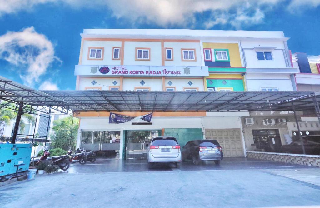 a white car parked in front of a building at grand koetaradja permai hotel in Luengbata