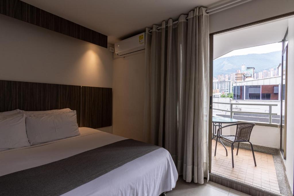 麥德林的住宿－Hotel Torre Poblado，酒店客房设有一张床和一个阳台。