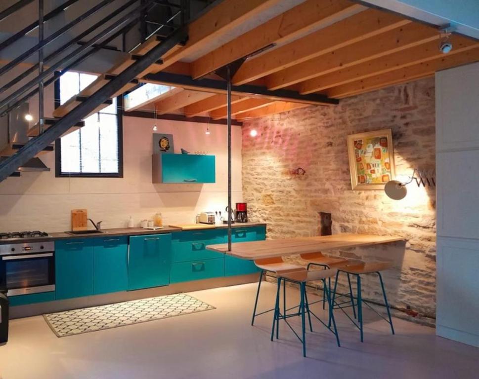 a kitchen with green cabinets and a wooden table at Holiday Loft 58 in Arbois