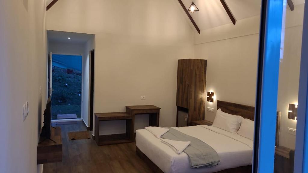 1 dormitorio con cama, mesa y ventana en Preethys Holiday Home, en Munnar