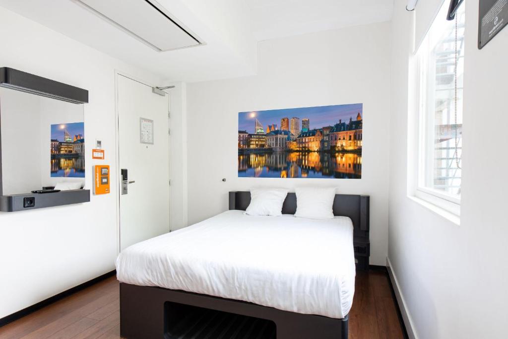 ein Schlafzimmer mit einem Bett und einem Wandgemälde in der Unterkunft easyHotel The Hague City Centre in Den Haag