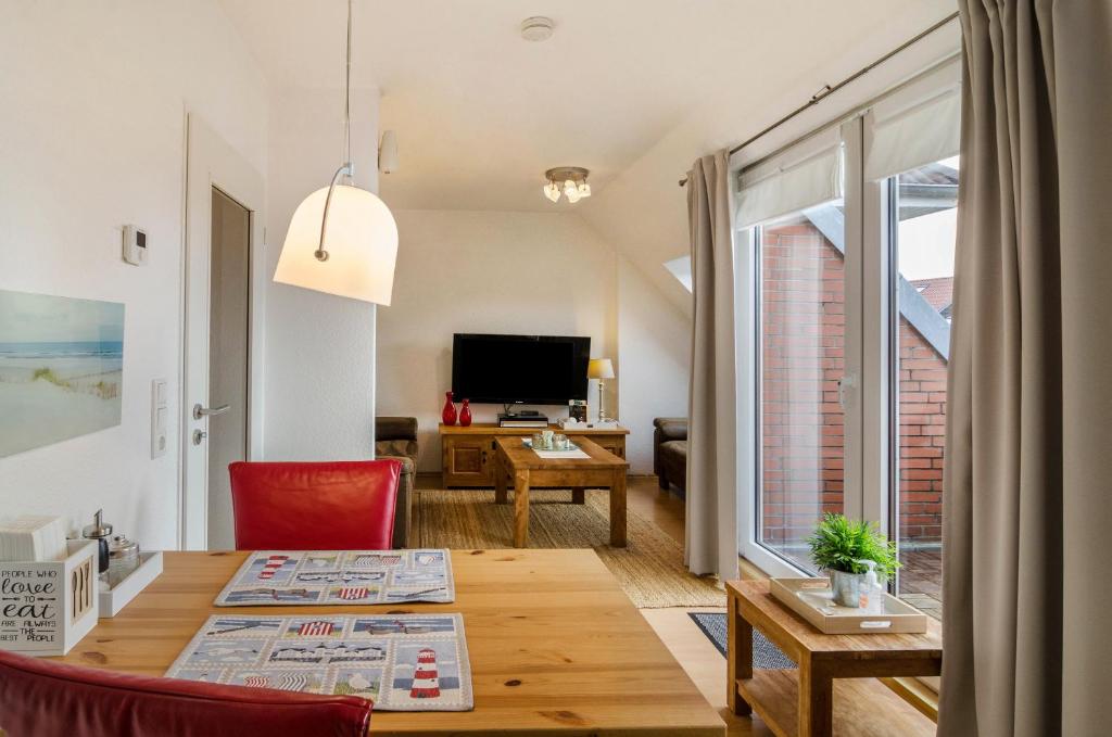 sala de estar con mesa y ventana grande en Windrose, en Wilhelmshaven