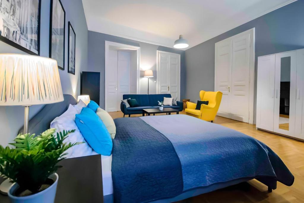 um quarto com uma cama azul e uma sala de estar em R171 Elitehost Ráday Apartment em Budapeste