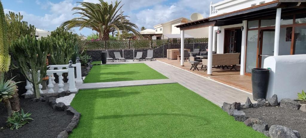un jardín con césped verde en una casa en Casa De Nefertiti, en Playa Blanca