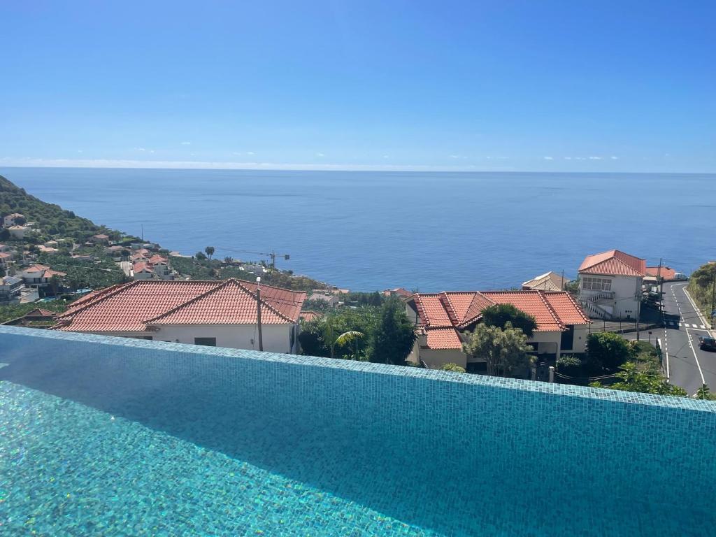 a swimming pool with a view of the ocean at Villa Sea View in Arco da Calheta