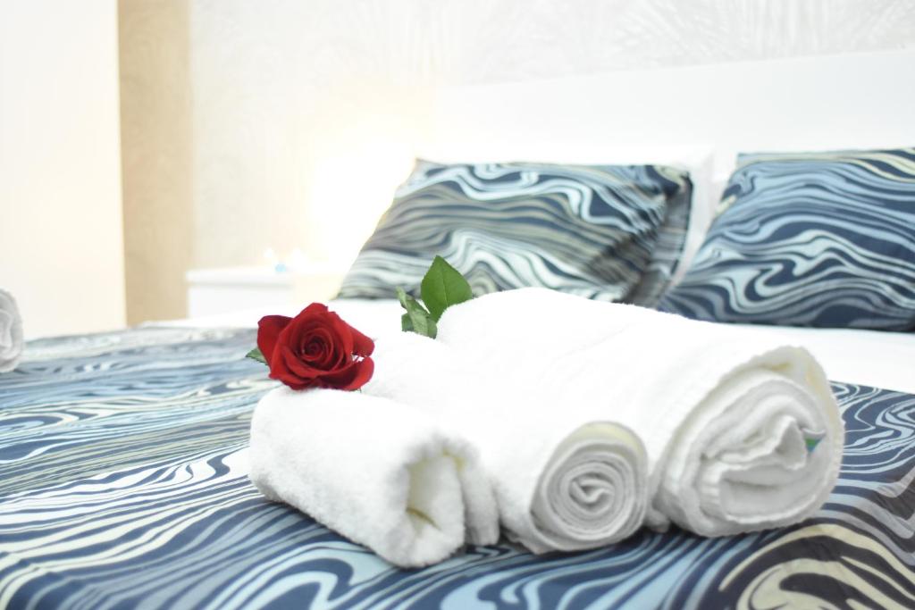 una pila de toallas y una rosa en una cama en Cico Art Suite, en Nápoles