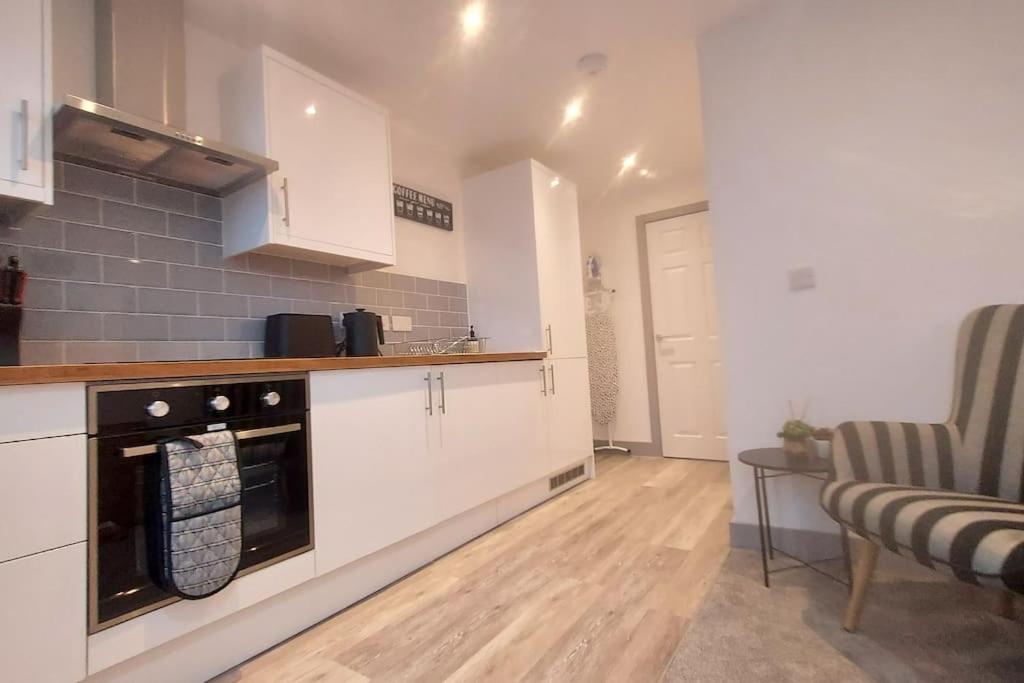 a kitchen with white cabinets and a counter top at 301 Grosvenor House-City Centre in Wakefield