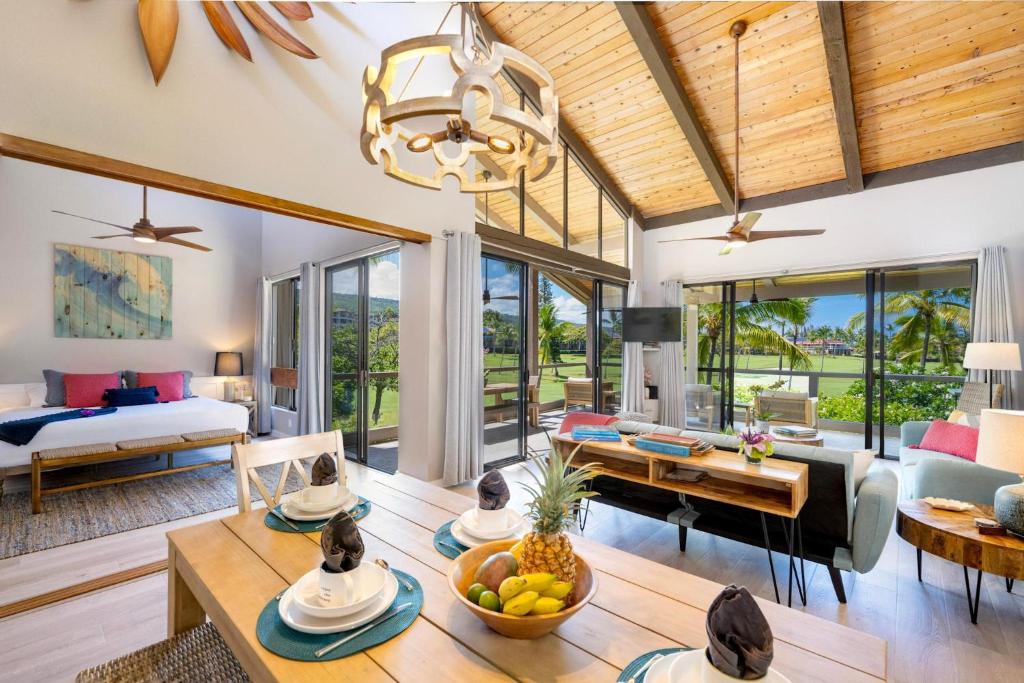 a living room with a bed and a table at CheCaHale: Gorgeous Top Floor Corner With AC in Kailua-Kona