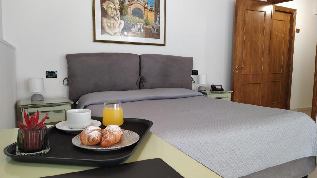 a bed with a tray with two plates of food on it at Villa Scaduto Residence in Bagheria