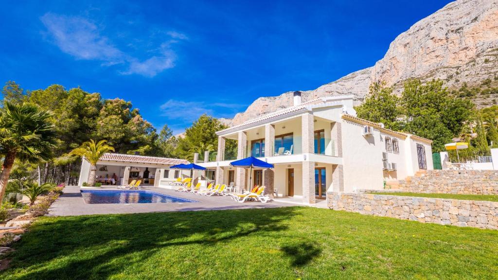 a house with a swimming pool in front of a mountain at Casa Tranquila in Jávea