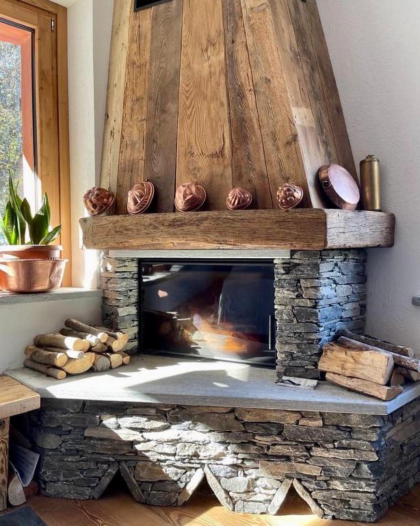 a living room with a stone fireplace at Hotel Edelweiss in Limone Piemonte