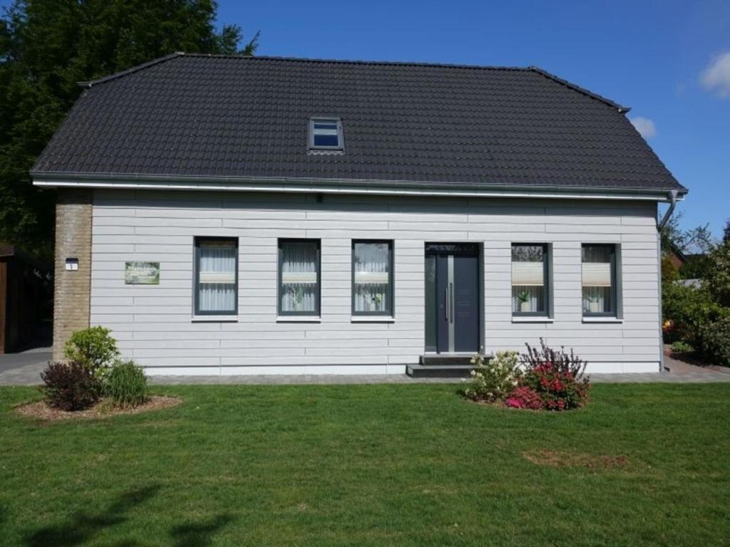 a white house with a black roof at Ferienwohnung Strauß in Neuberend