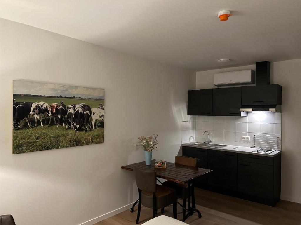 una cocina con una pintura de un rebaño de vacas en Hotel Nijeveen, en Nijeveen