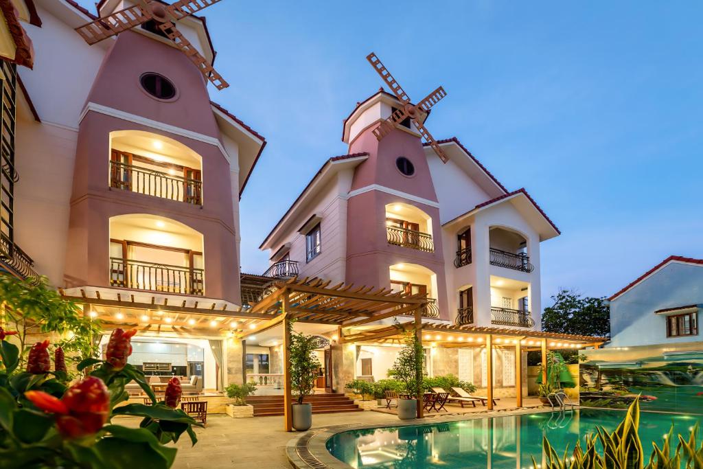 a house with a swimming pool and a windmill at Ong Tam Villa Hoi An in Hoi An
