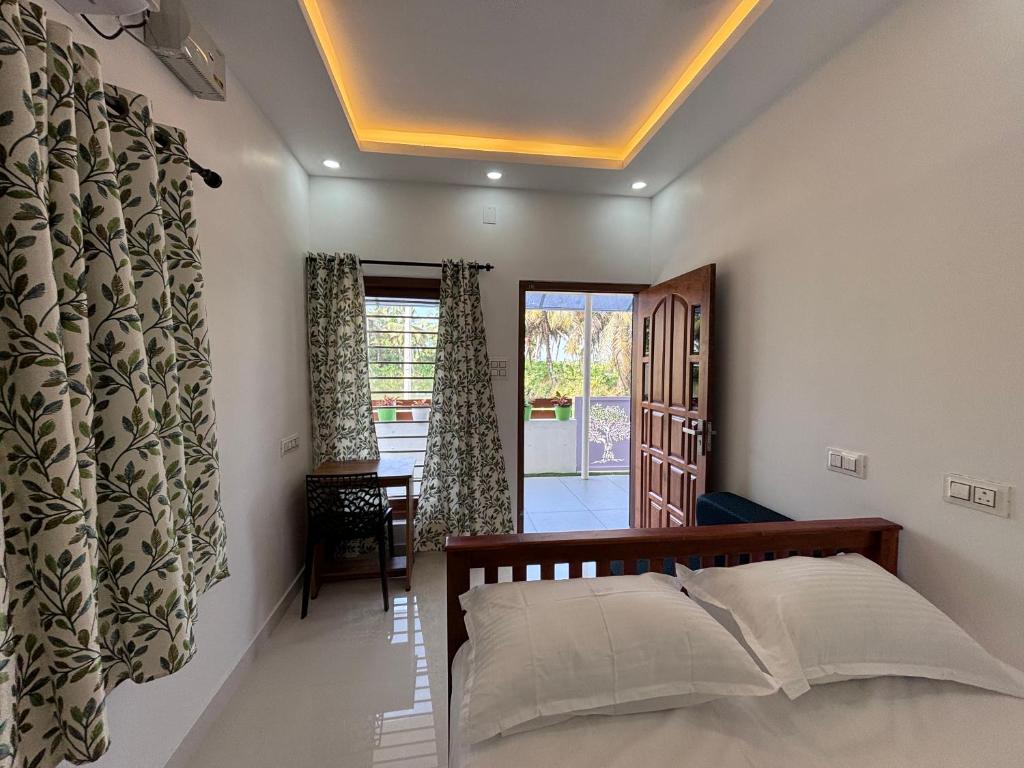 a bedroom with a bed and a room with a window at Mali Homestays in Cochin