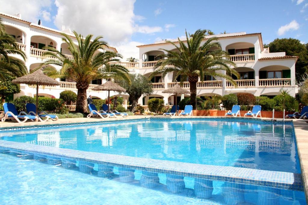 a large swimming pool in front of a hotel at La Ardilla in Cala Santanyi