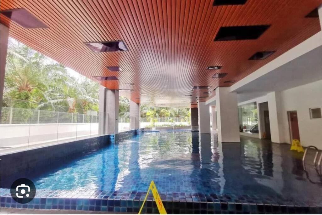 a swimming pool in a building with a large window at Fuji In Muji in Sitiawan