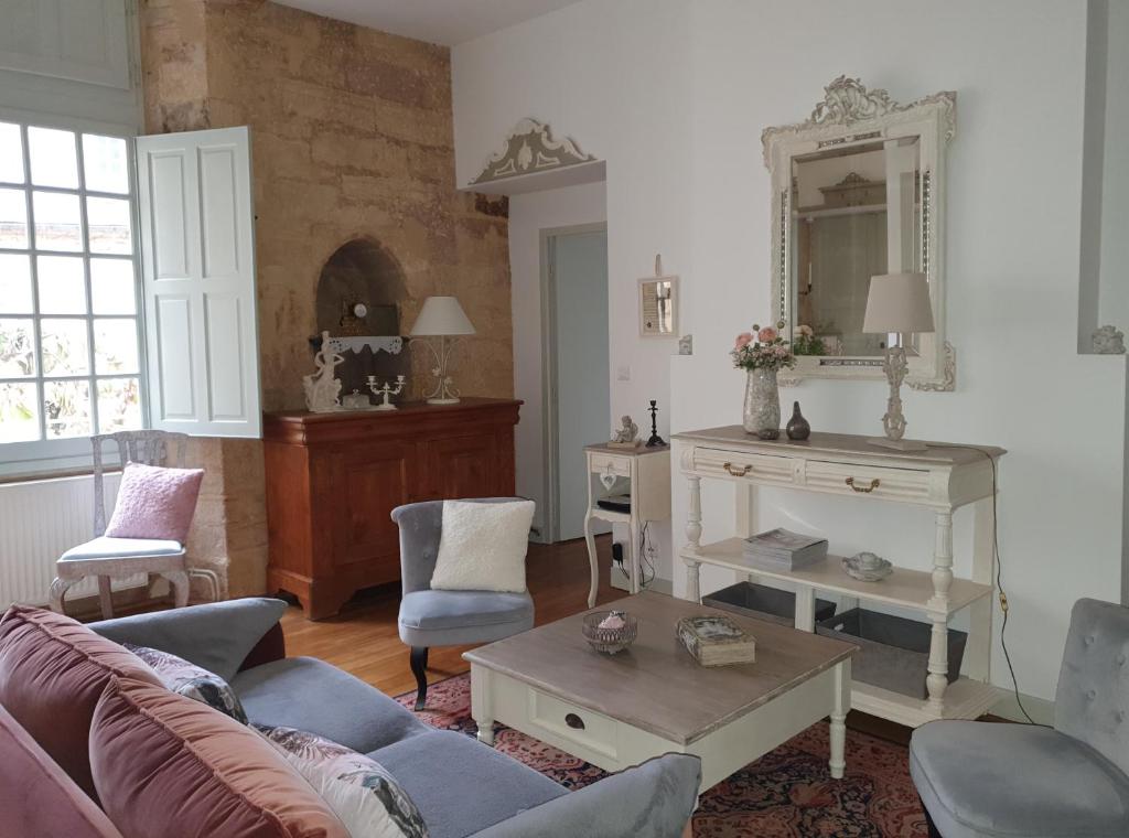 a living room with a couch and a mirror at L'appart d'à coté 1 chambre in Sarlat-la-Canéda
