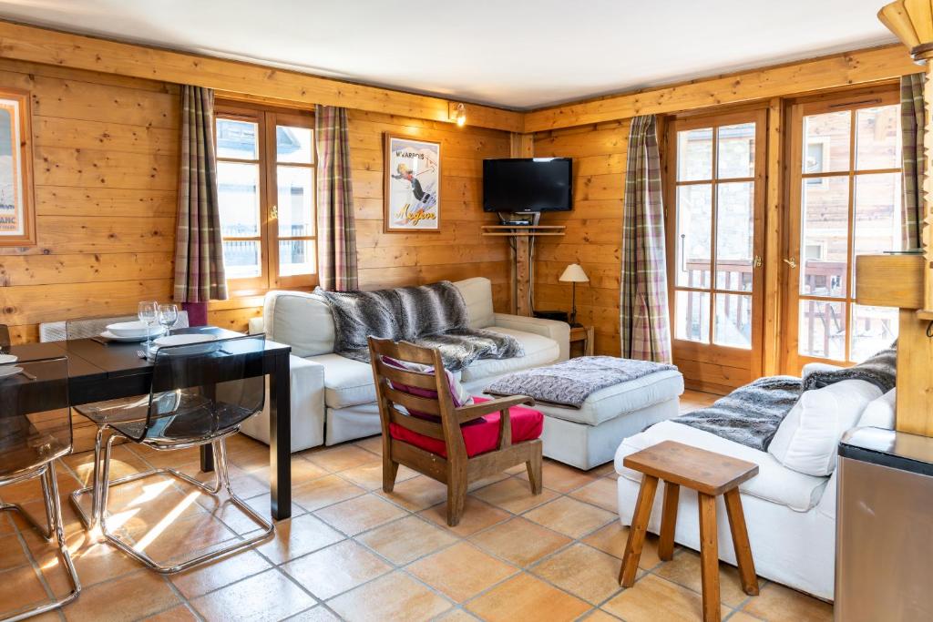 a living room with a couch and a table at Bel appartement au coeur du village in Megève