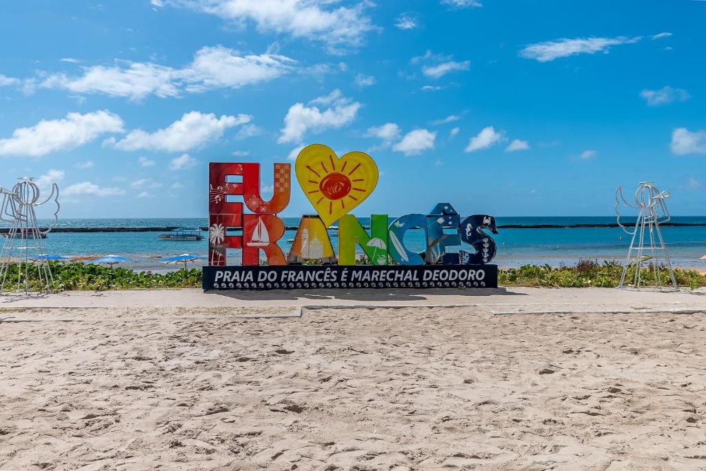 a sign on the beach next to the beach at Pé na areia, Praia do Francês in Marechal Deodoro