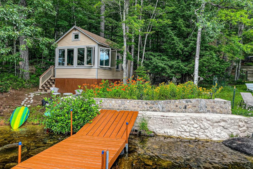 a small cabin in a garden with a wooden bench at Waterfront Serenity in Raymond