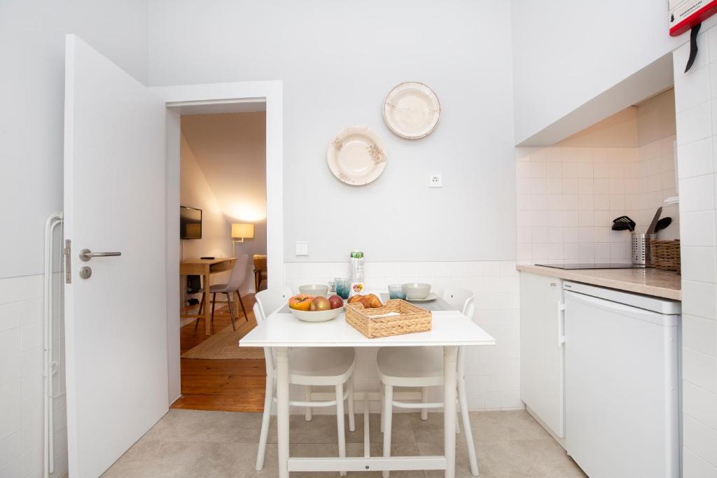 リスボンにあるLive like a local @ Casa da Esquina - Wifi & A/Cの白いキッチン(白いテーブルと椅子付)