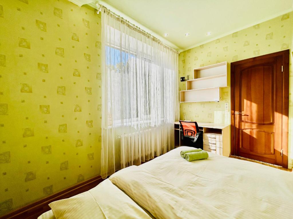 ein Schlafzimmer mit einem großen Bett und einem Fenster in der Unterkunft Kholodnaya gora in Kharkov