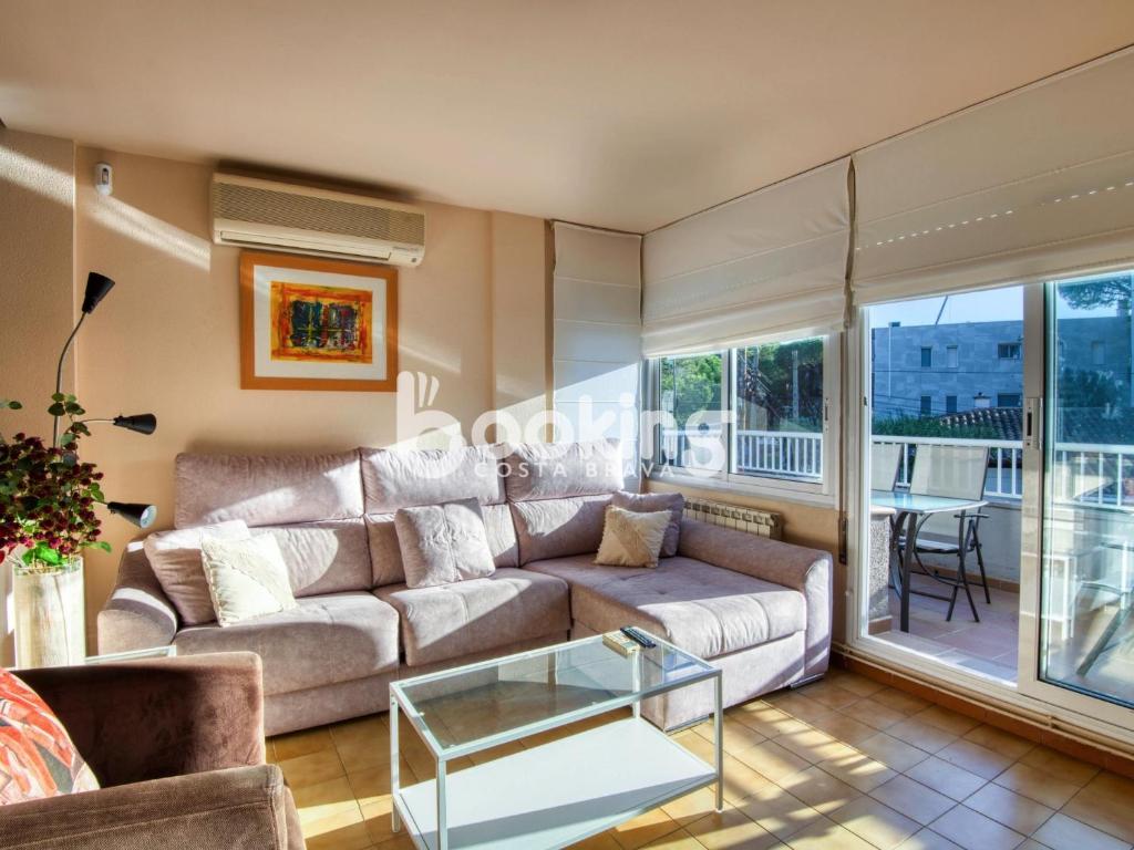 ein Wohnzimmer mit einem Sofa und einem Glastisch in der Unterkunft Saromar III in Platja  d'Aro