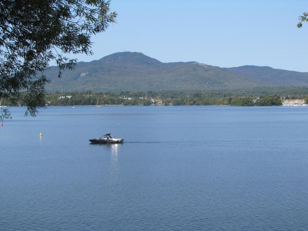a person in a boat on a large lake at Location Tourisme Estrie - Oberge du Village in Magog-Orford