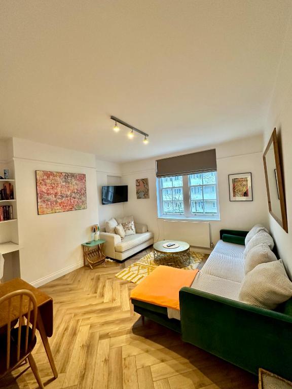 a living room with a couch and a table at Bright and Airy Two Bedroom Apartment in London