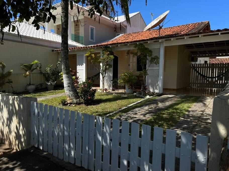une clôture blanche devant une maison dans l'établissement Recanto da Praia Linda, à São Pedro da Aldeia