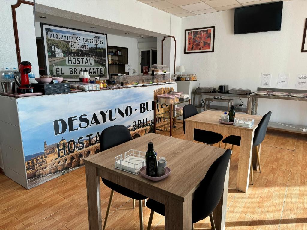 - un restaurant avec des tables et des chaises dans une salle dans l'établissement Hostal El Brillante - Alojamientos El Duque, à Cordoue