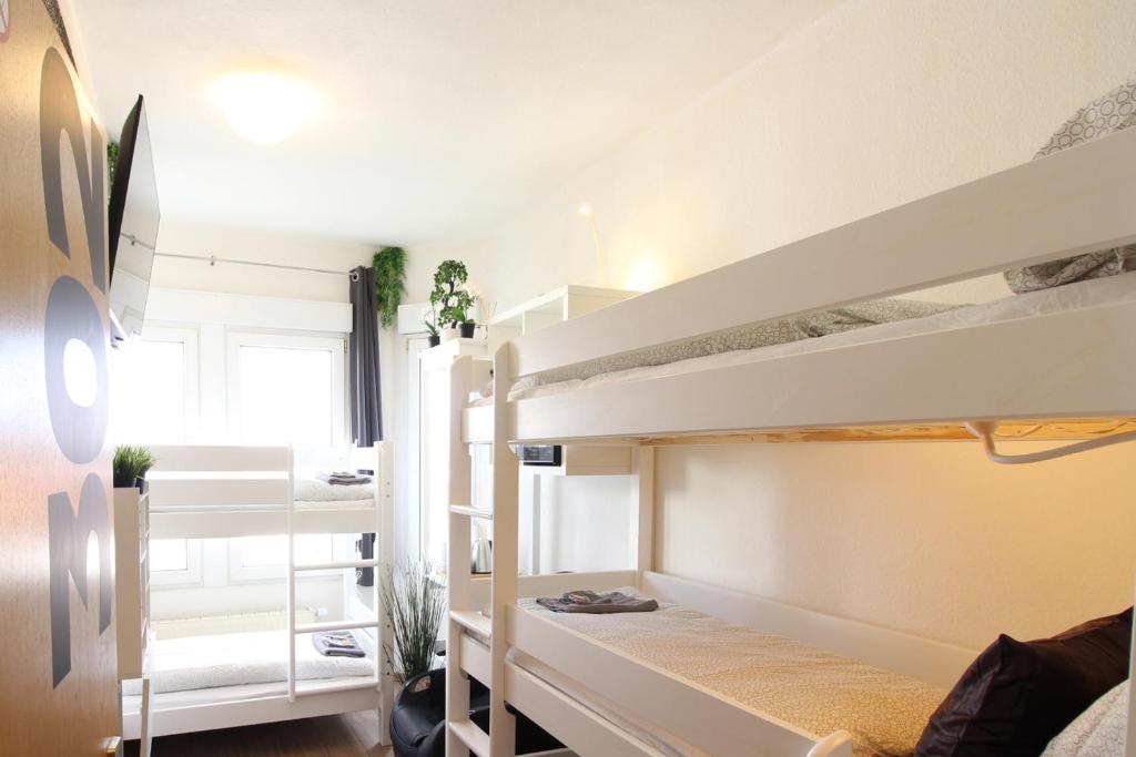 1 dormitorio con 2 literas en una habitación en Hotel Ulm Zentrum - Komplettes Zimmer, Hochbett, Android TV & eigenem Bad - perfekt für Familien & Gruppen, en Ulm