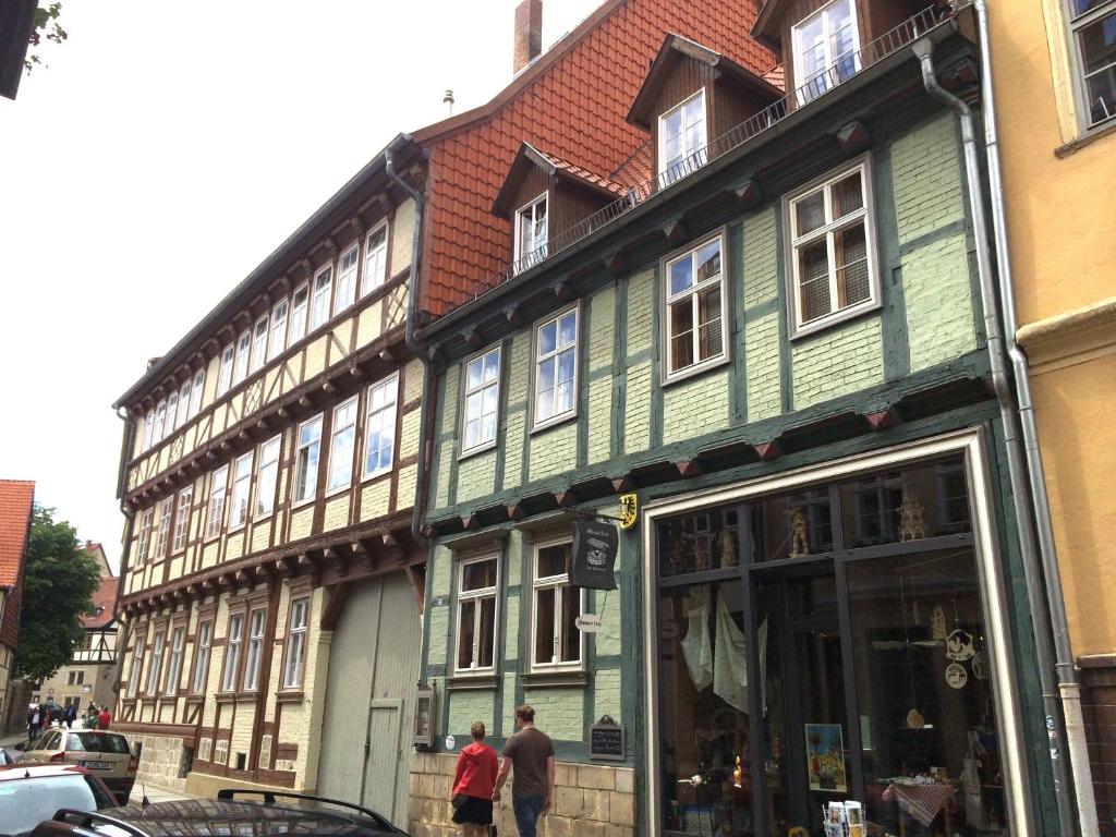 a green building with people walking in front of it at Quartier am Brunnen in Quedlinburg