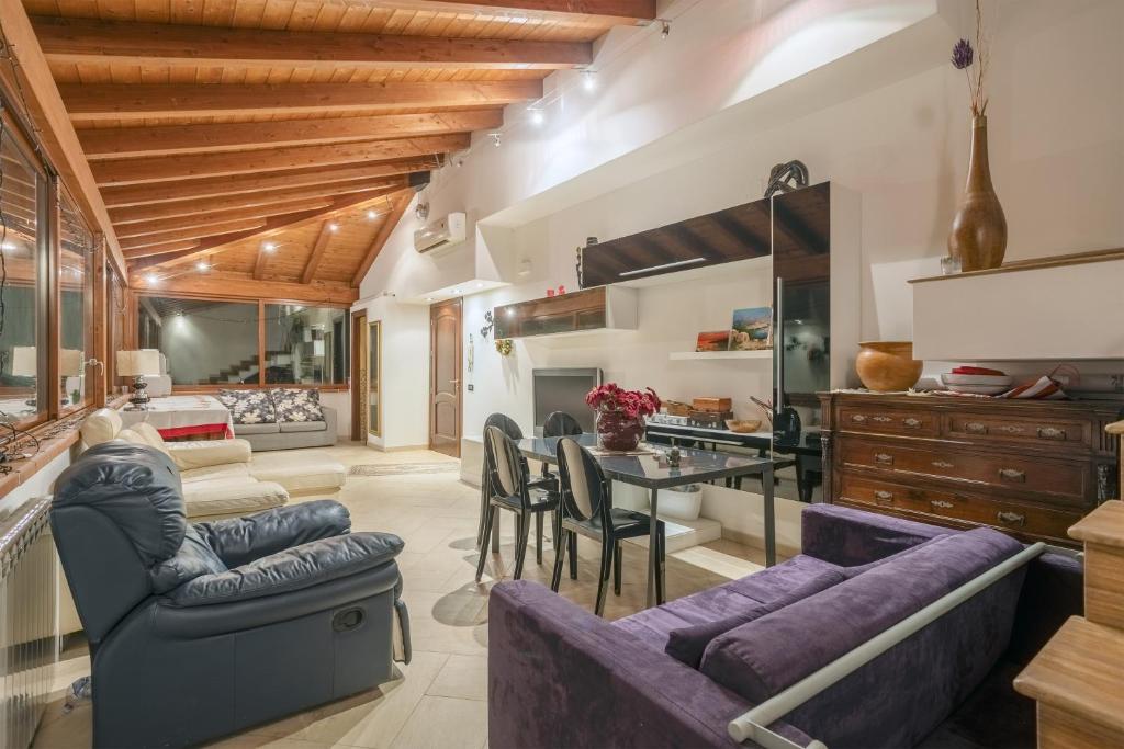 a living room with purple furniture and a table at Appartamento in villa con piscina 2 in Palermo