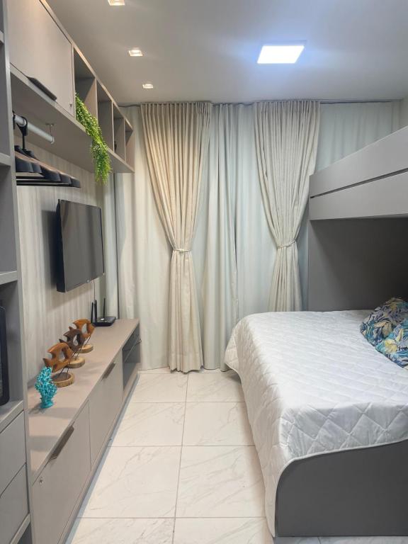 a bedroom with a bed and a flat screen tv at Porto de galinhas in Porto De Galinhas