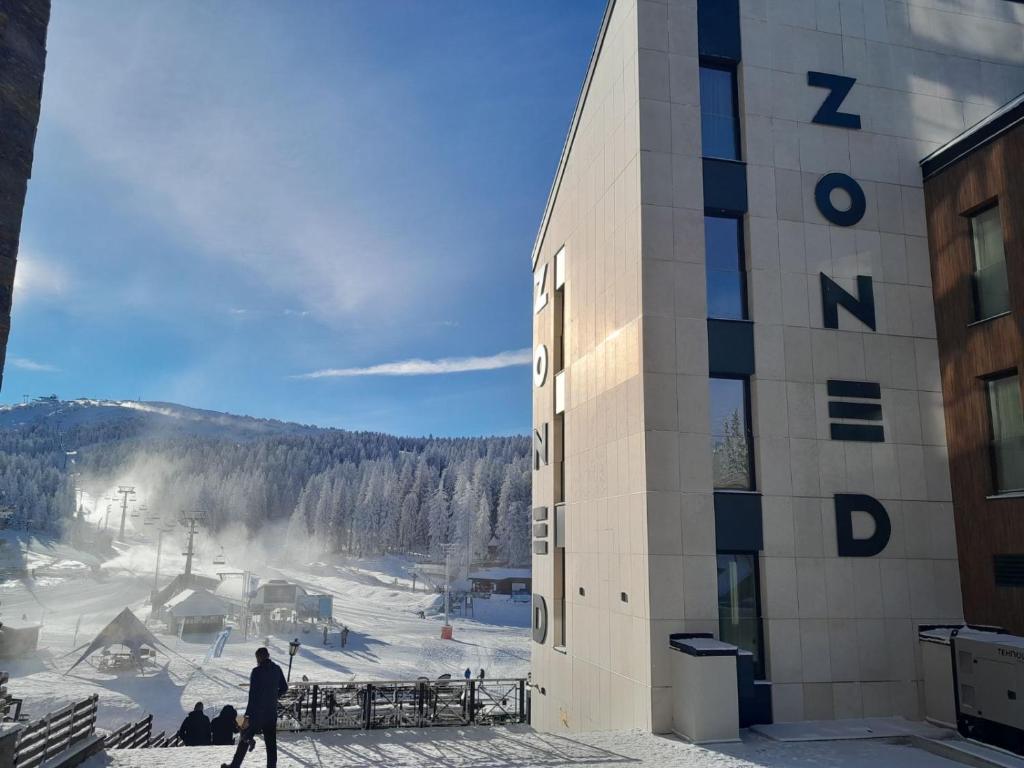 a man is standing outside of a ski resort at Stefany in Kopaonik