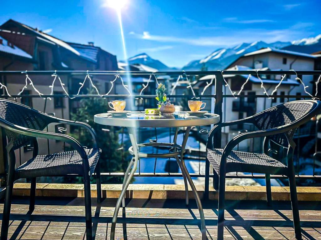 a table and chairs sitting on a balcony with a table and chairs at IZ VIEW Apartment in Bansko