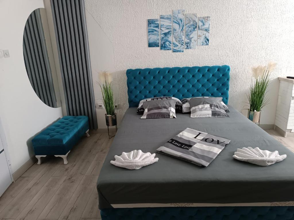 ein Schlafzimmer mit einem blauen Bett und einem blauen Sofa in der Unterkunft Apartman u centru 1 in Šid