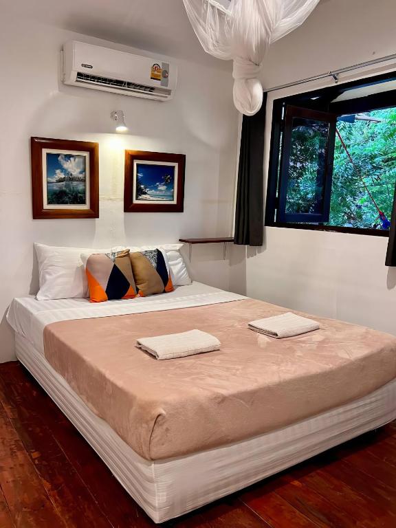 Ko Phangan Haad Yao Beach Hotel في Haad Tian: غرفة نوم بسرير كبير عليها منشفتين