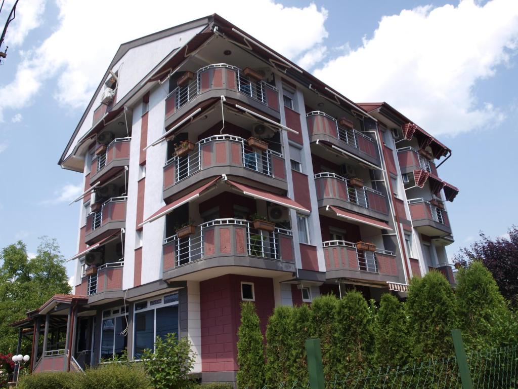 een roze en wit gebouw met balkons bij Fantastik Ayaz Apartments in Ohrid
