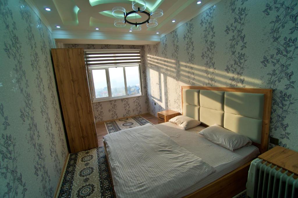 een slaapkamer met een bed in een kamer met een raam bij Royal apartment 2 in Doesjanbe