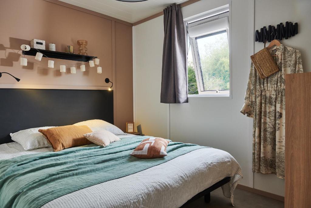 een slaapkamer met een bed en een raam bij Camping les Campagnes in Rocamadour