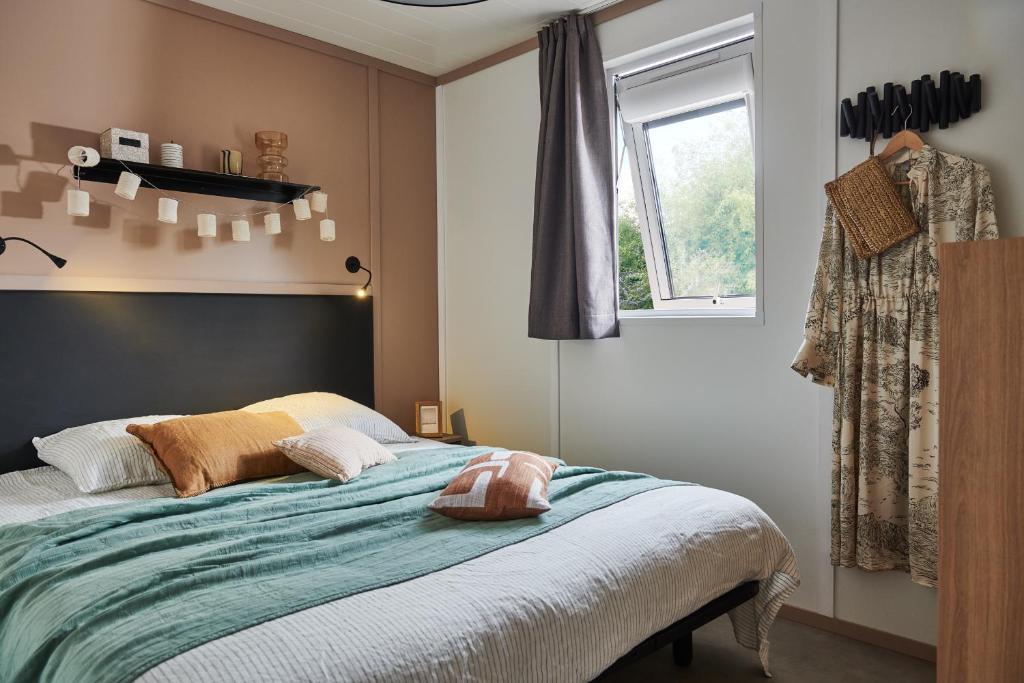 罗卡马杜尔Camping les Campagnes的带床和窗户的卧室