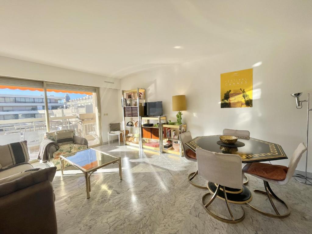 un salon avec une table et un canapé dans l'établissement Vintage Apartment by Welcome to Cannes, à Cannes