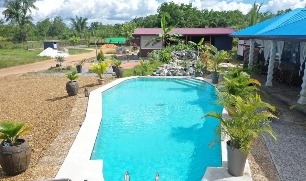 una piscina en un patio con palmeras en Eco Resort, en Carrefour de Mana