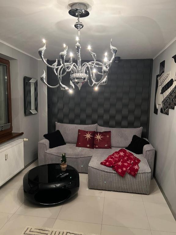 sala de estar con sofá y lámpara de araña en Apartament przy Krupówkach, en Zakopane