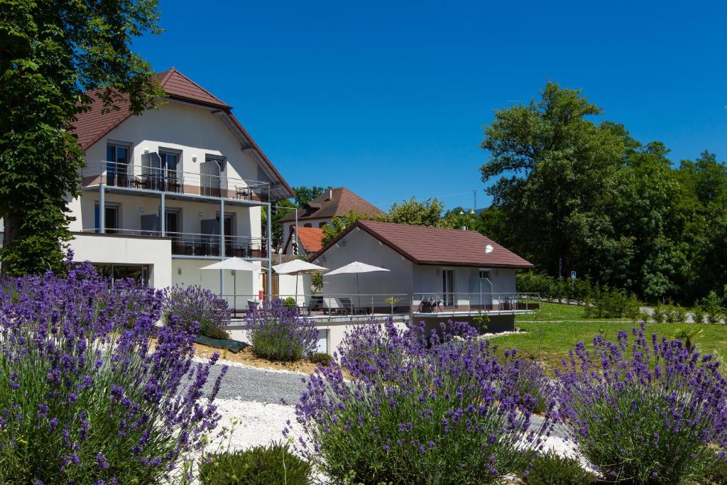 uma casa com flores roxas em frente em Hotel Blanc em Marigny-Saint-Marcel